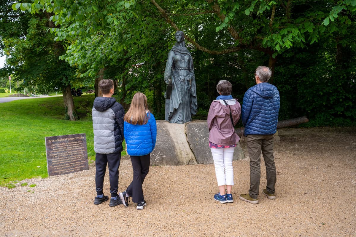 Family admiring the bronze statue of Grace O’Malley on the grounds of Westport Estate.